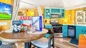 A cozy kitchen with a dining table, a microwave, a stove, and a sink.
