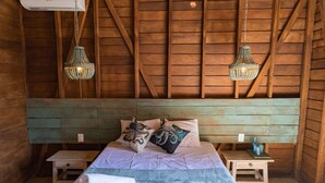 A wooden cabin bedroom with a bed, two nightstands, and hanging light fixtures. - Krak-Inn Holbox Self Check In (Isla Holbox)