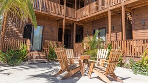 A wooden multi-story building with balconies, outdoor seating, and tropical plants. - Krak-Inn Holbox Self Check In (Isla Holbox)