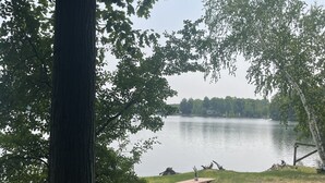 Une table de pique-nique au bord d’un lac, avec des arbres au premier plan.