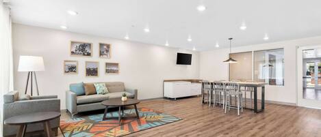 A modern living room with a sofa, coffee table, and dining area.