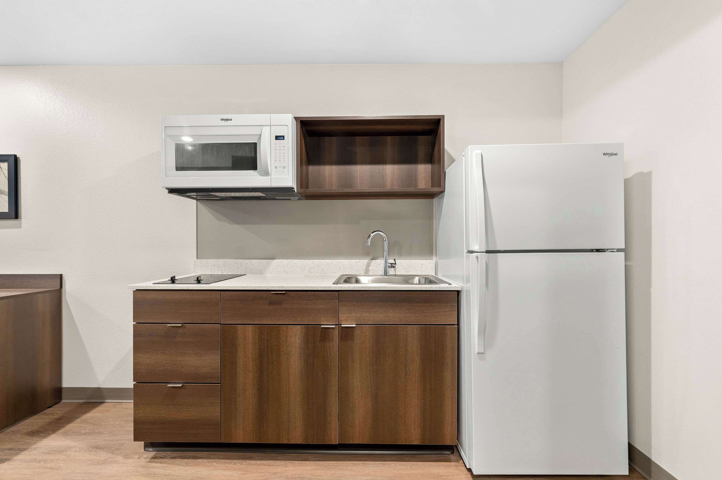 A compact kitchen with a microwave, sink, and refrigerator.