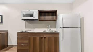 A compact kitchen with a microwave, sink, and refrigerator.