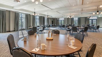 A conference room with round tables, chairs, and a projector.