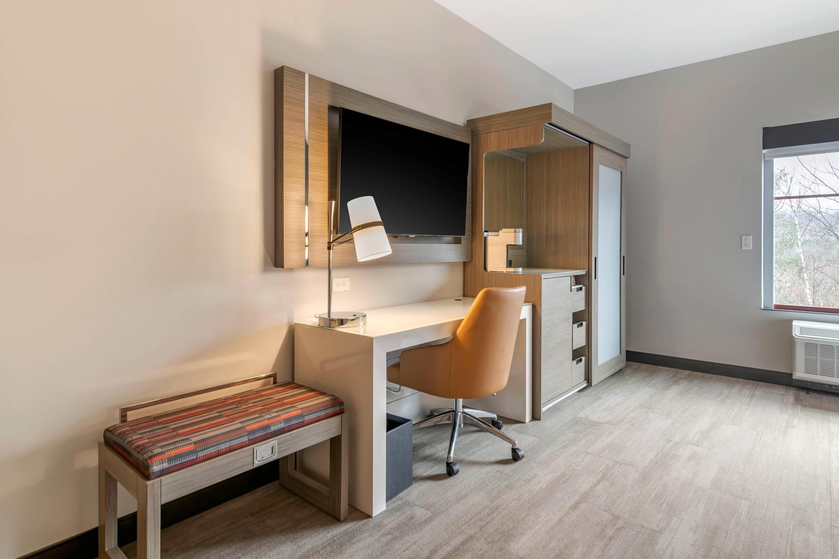 A modern office space with a desk, chair, and bench.