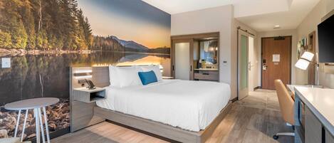 Habitación de hotel moderna con una cama grande, un escritorio y vistas a un lago representadas en un mural.