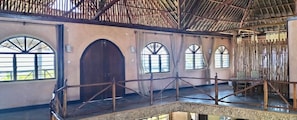 A spacious interior with a high ceiling, arched windows, and a central wooden door. - Room-38m2 Turtle Suite in a 560 m2 Villa (Shimoni)