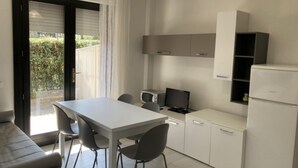 Una cocina compacta con mesa, sillas, microondas y refrigerador.