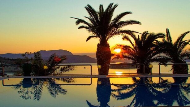 A sunset over a calm body of water with palm trees and mountains in the background. - Coco Seaview Apartment, 60sec Walk From Beach! (Apokoronas)