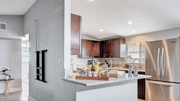 A modern kitchen with a central island, stainless steel appliances, and wooden cabinets. - Luxury 4BR 2BA House with Pool Spa Billiard Only 6 minutes to the Strip (Las Vegas)