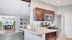 A modern kitchen with granite countertops, stainless steel appliances, and wooden cabinets. - Luxury 4BR 2BA House with Pool Spa Billiard Only 6 minutes to the Strip (Las Vegas)