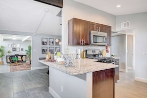 A modern kitchen with granite countertops, stainless steel appliances, and wooden cabinets.