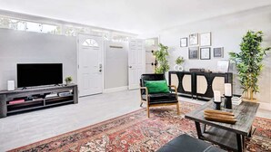 A living room with a TV, a sofa, a coffee table, and a rug. - Luxury 4BR 2BA House with Pool Spa Billiard Only 6 minutes to the Strip (Las Vegas)
