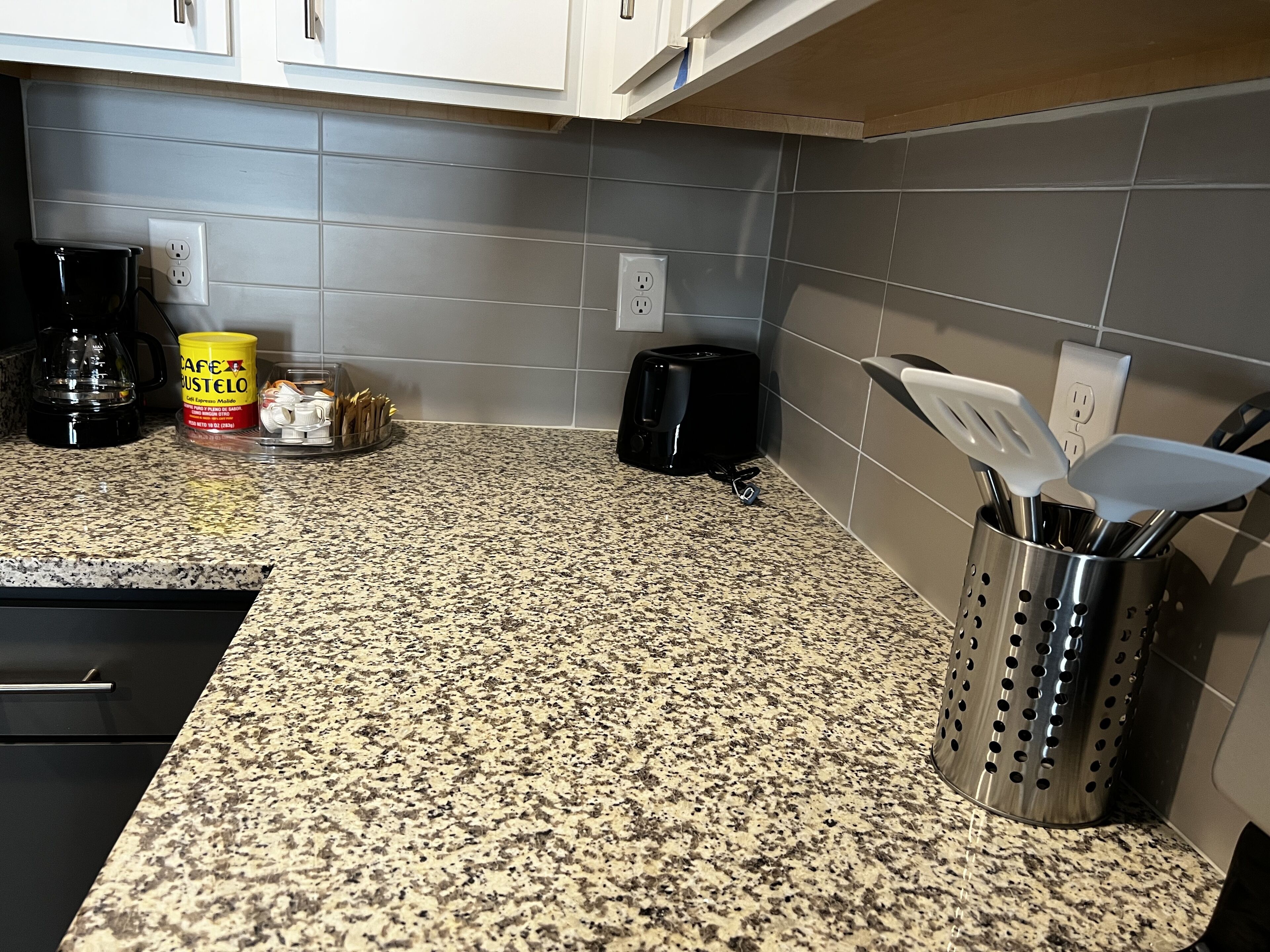 Una cucina con piani di lavoro in granito, una macchina per il caffè, un tostapane e un portauova.