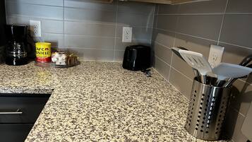 Una cucina con piani di lavoro in granito, una macchina per il caffè, un tostapane e un portauova.