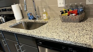 A kitchen with granite countertops, stainless steel appliances, and a dishwasher.