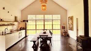 Une cuisine spacieuse avec une grande fenêtre, une table en bois et une cuisinière intégrée.