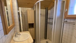 A corner bathroom with a sink, mirror, shower, and tiled walls. - Chalet Le Castor: in the center of Chatel (Châtel)