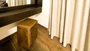 A modern bathroom with a large mirror, a wooden bench, and a curtain.