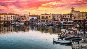 Ein Hafen mit Booten, Gebäuden am Wasser und einem Abendhimmel.
