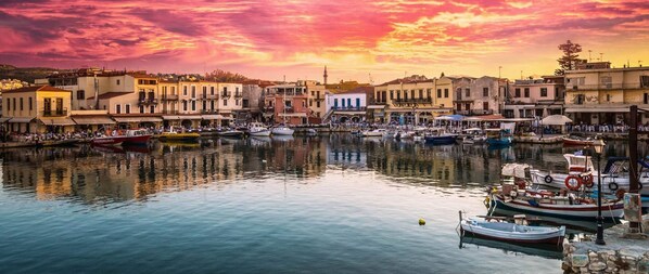 Ein Hafen mit Booten, Gebäuden am Wasser und einem Abendhimmel.