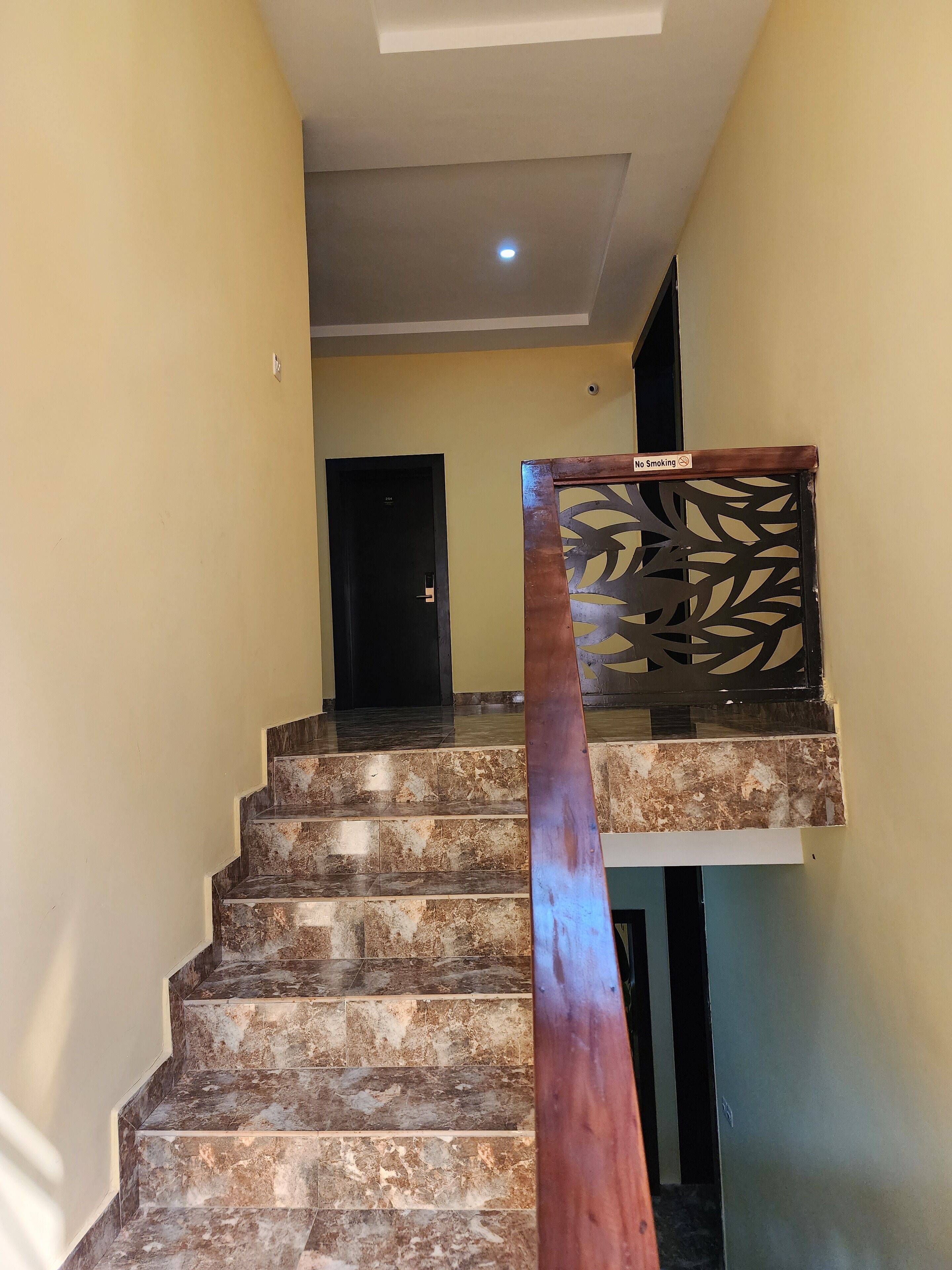 A staircase with a metal handrail and a decorative panel at the top.
