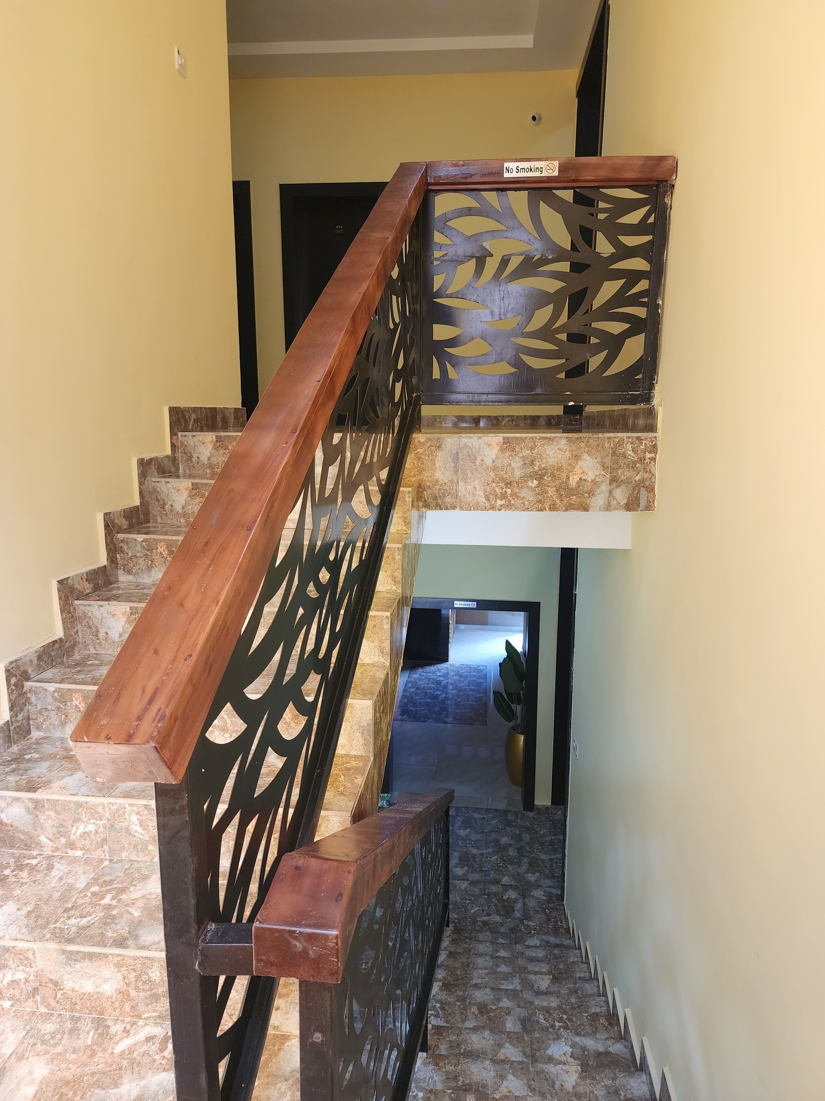 A staircase with wooden handrails and a decorative metal railing.