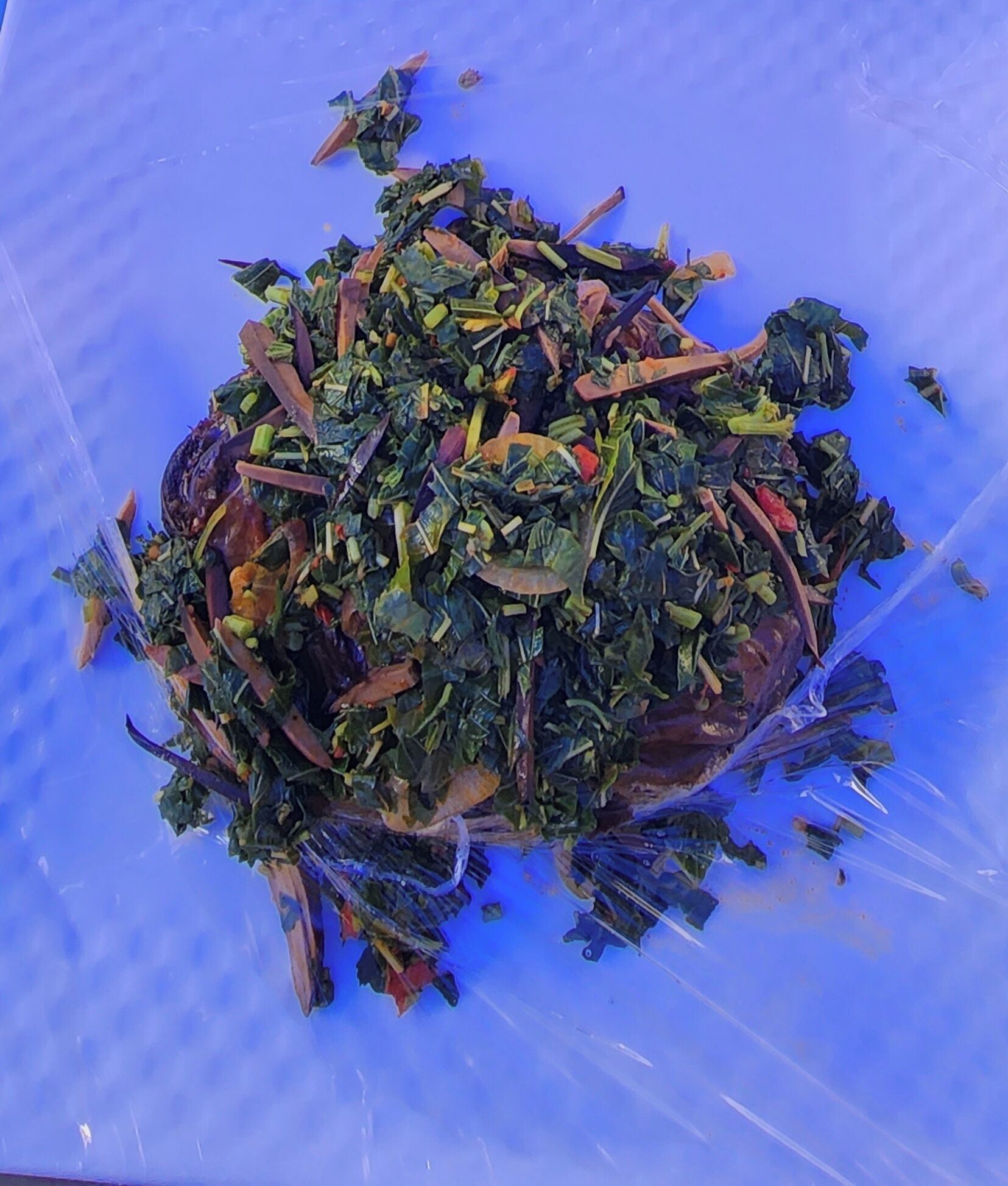A pile of mixed vegetables on a blue surface.