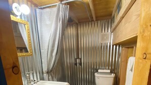 Un baño pequeño con lavamanos, inodoro y cortina de ducha.