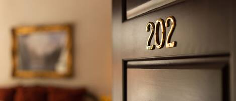 A close-up of a door with the number 202 in gold lettering.