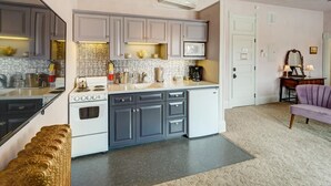 Una cocina compacta con estufa, microondas y muebles de cocina modernos.