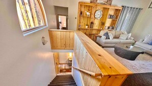 A wooden staircase leading to a living area with a sofa and a coffee table. - Timber Terrace - .9 mi Downtown *pet friendly (Prescott)