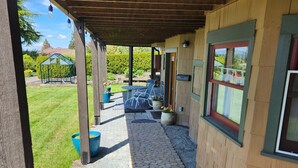 Un patio couvert avec un chemin de pierre menant à un espace de détente extérieur.