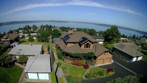 Un quartier résidentiel avec des maisons, un grand plan d’eau en arrière-plan et un ciel dégagé.