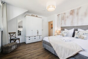 A bedroom with a bed, a wardrobe, a chair, and a lamp.