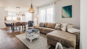 Un salon moderne avec un canapé, une table basse et un coin repas.