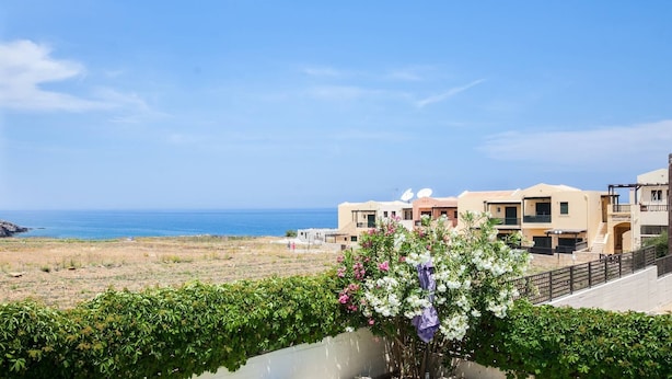 A coastal hotel with multiple buildings, a view of the sea, and a garden with flowering plants. - Family Villa Hera With Sea View (Mylopotamos)