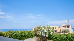 A coastal building with a view of the sea, surrounded by greenery and flowering plants. - Family Villa Hera With Sea View (Mylopotamos)
