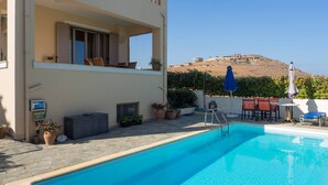 A swimming pool with a view of a hill, outdoor furniture, and potted plants. - Family Villa Hera With Sea View (Mylopotamos)