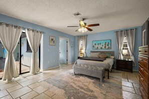 Cozy retreat with a large bed, nightstand, and dresser, plus a ceiling fan for ventilation.