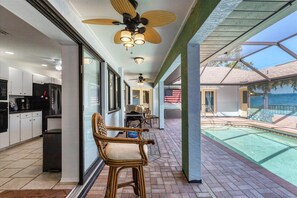 Enjoy meals in the kitchen with stainless steel appliances and dining area, then step out to the patio and pool with a clear view of the surrounding landscape.