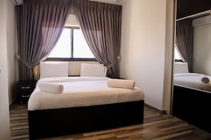 Relax in a spacious room with a large bed, bedside table, and mirror.