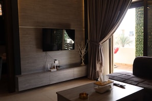 Relax in this stylish living room with a flat-screen TV, console, and glass-topped coffee table.
