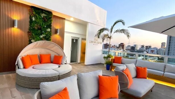 A rooftop terrace with a modern design, featuring a seating area with sofas and a circular seating arrangement. - Central Suites Tower (Santo Domingo)