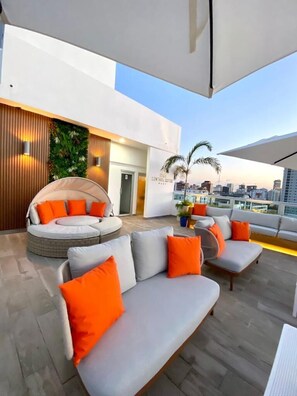 A rooftop terrace with a modern design, featuring a seating area with sofas and a circular seating arrangement. - Central Suites Tower (Santo Domingo)
