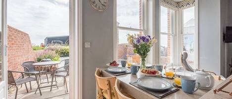 Enjoy meals with a view from this dining area, featuring a large window and outdoor seating.
