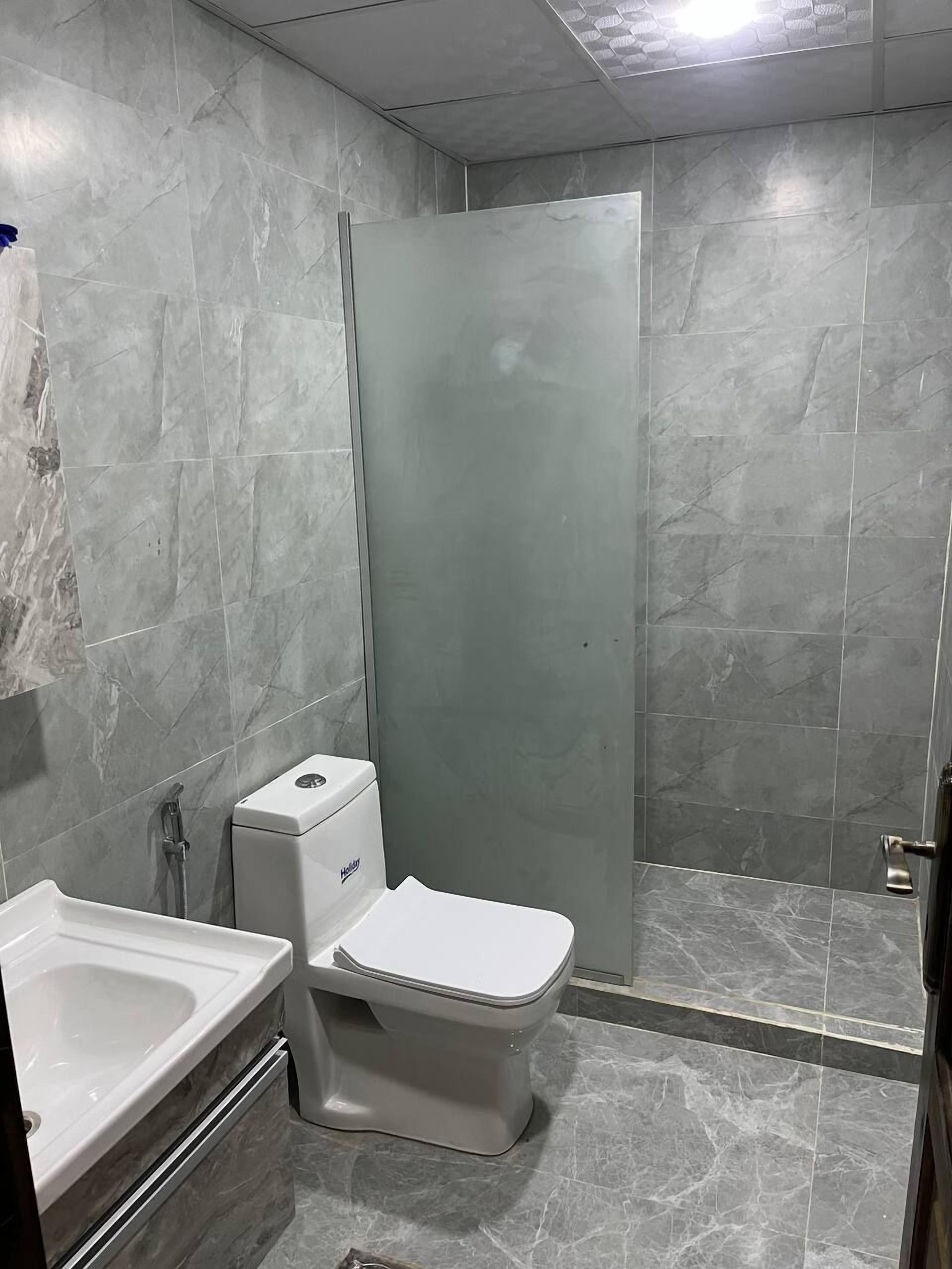 Ein Badezimmer mit Toilette, Duschkabine und Waschbecken.