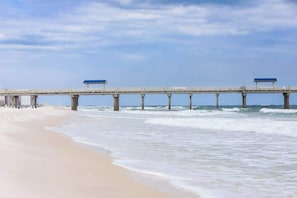 A pier extending into the ocean with a beach on one side. - 10 Beds sleeps 16 with Arcade GAME ROOM & POOL! (Orange Beach)