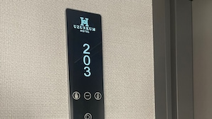Painel digital de elevador com o número 203 e o logotipo do Hotel Uzunkum.