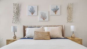 Ein Schlafzimmer mit einem Bett, zwei Nachttischen und Wandbildern.